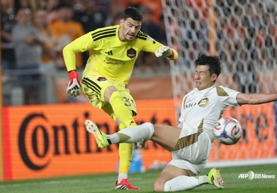 손흥민(오른쪽)이 1일(한국시간) 미국 텍사스주 휴스턴의 쉘 에너지 스타디움에서 열린 2026 미국 프로축구 메이저리그사커(MLS) 2라운드 경기 중 상대 골키퍼에 태클을 시도하고 있다. /AFPBBNews=뉴스1