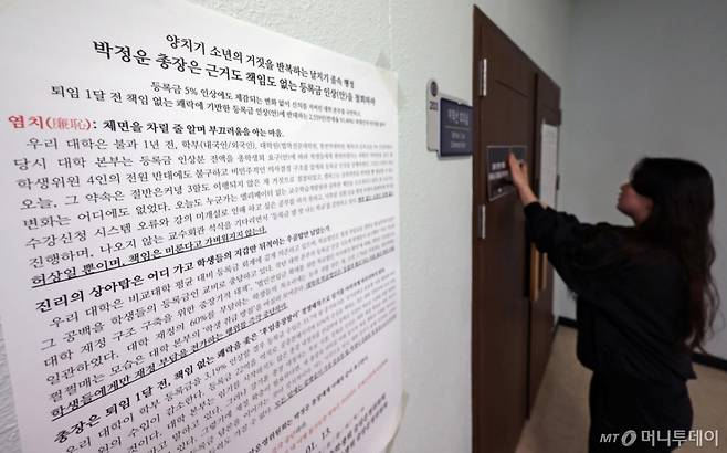 [서울=뉴시스] 조성우 기자 = 한국외국어대학교 총학생회 소속 학생이 1월 21일 오전 서울 동대문구 한국외대 서울캠퍼스 본관 제1차 등록금심의위원회 회의실 앞에 등록금 인상 반대 대자보와 피켓을 붙이고 있다. 2026.01.21. /사진=조성우