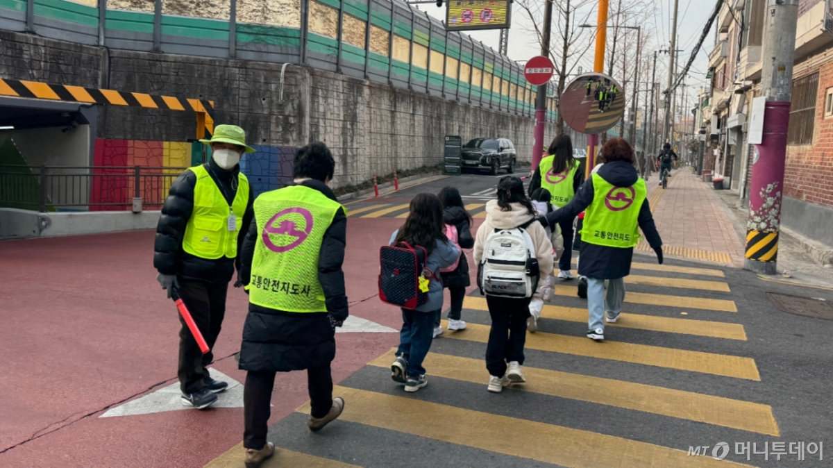 교통안전지도사들이 신계초등학교 학생들을 인솔해 횡단보도를 건너고 있다./사진=최문혁 기자.