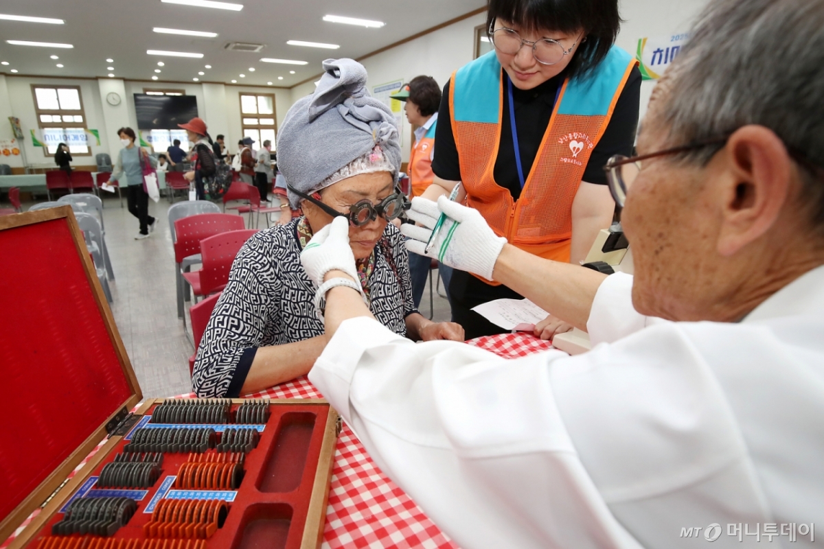 5일 오전 대구 중구 서문교회에서 열린 '2025년 제1회 중구 한마음순회봉사' 행사장을 찾은 어르신이 돋보기를 맞추기 위해 시력검사를 받고 있다./사진=(대구=뉴스1) 공정식 기자