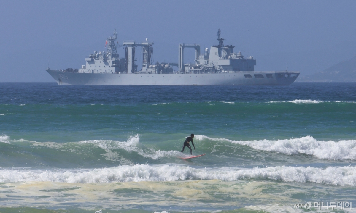 (케이프타운 로이터=뉴스1) 이정환 기자 = 중국, 러시아, 이란 등 '브릭스 플러스' 국가들의 남아프리카해 합동 해상훈련을 앞둔 7일(현지시간) 남아프리카공화국 케이프타운의 사이먼스타운 해군기지 인근 파슬 베이에서 한 서퍼가 중국 선박 앞에서 서핑을 즐기고 있다. 2026.01.07. ⓒ 로이터=뉴스1 Copyright © 뉴스1. All rights reserved. 무단 전재 및 재배포, AI학습 이용 금지. /사진=(케이프타운 로이터=뉴스1) 이정환 기자