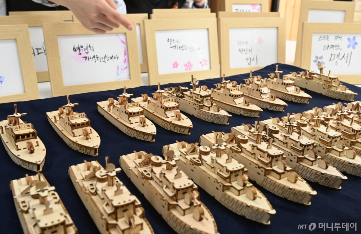 [수원=뉴시스] 김종택 기자 = 제10회 서해수호의 날을 나흘 앞둔 24일 천안함 피격 전사자 고(故) 박경수 상사의 모교인 경기도 수원시 삼일공업고등학교에서 학생들이 추모의 마음을 담아 만든 천안함과 참수리 357호 모형을 살펴보고 있다.  서해수호의 날은 매년 3월 넷째 금요일로 제2연평해전, 천안함 피격, 연평도 포격 사건으로 희생된 서해수호 55용사를 기리기 위해 제정된 법정 기념일이다. 2025.03.24. jtk@newsis.com /사진=김종택