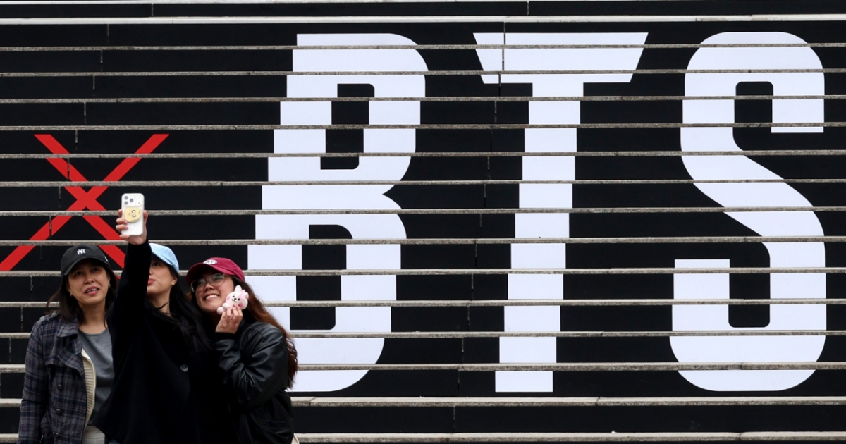 방탄소년단(BTS)의 서울 광화문광장 컴백 공연을 엿새 앞둔 15일 오후 서울 종로구 세종문화회관 계단에서 외국인관광객이 BTS 컴백 공연 관련 래핑 광고를 배경으로 기념촬영을 하고 있다. /사진=뉴시스 