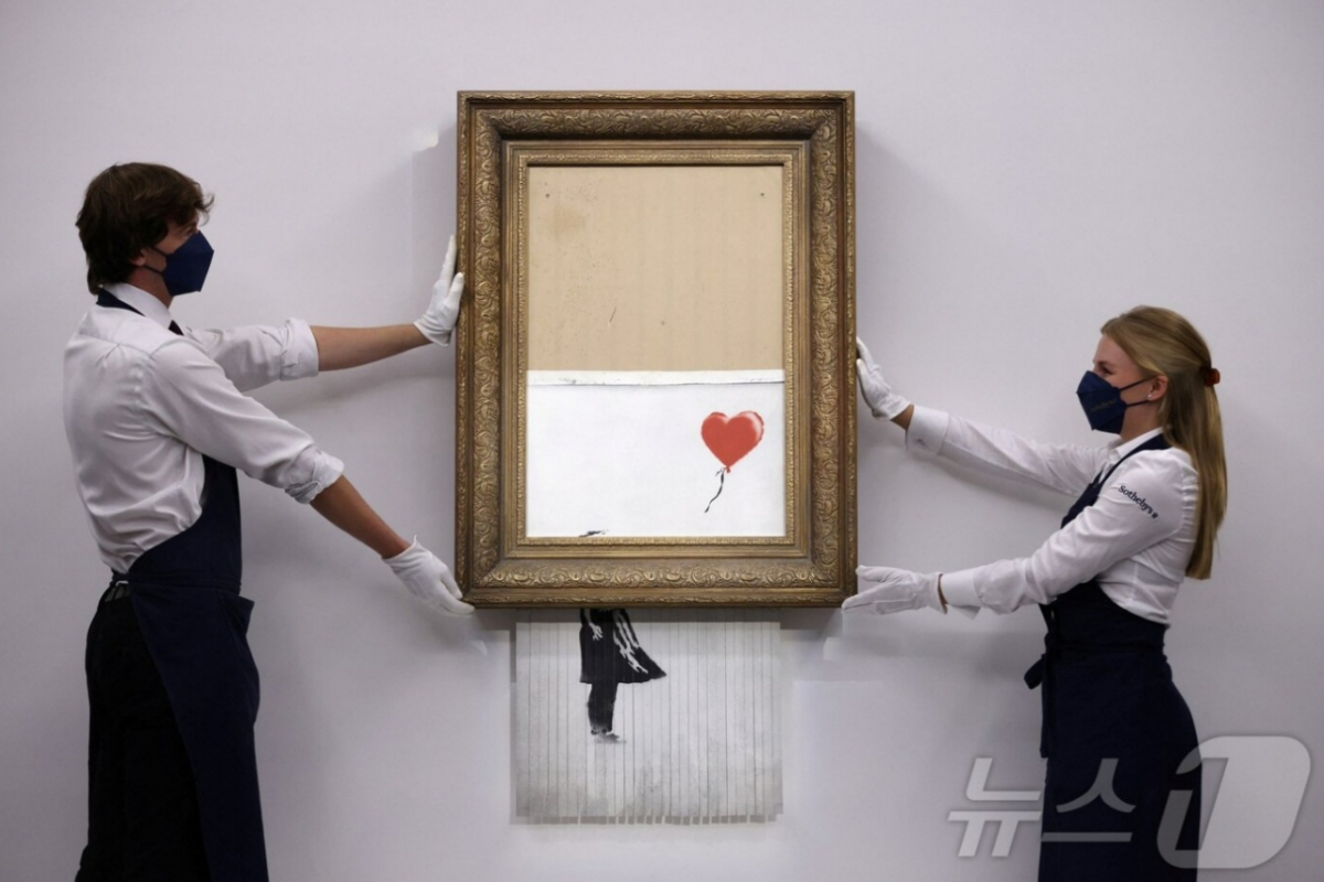 뱅크시 작품인 '풍선과 소녀'. 2018년 런던 소더비 경매에서 약 100만파운드(당시 약 16억원)에 낙찰된 직후 경매장에서 원격 조종을 통해 스스로 파쇄되는 충격적인 장면을 연출하며 더욱 유명해졌다. 이로 인해 '사랑은 쓰레기통에'(Love is in the Bin)라는 새로운 이름도 붙었다. 이후 3년 뒤인 2021년 다시 경매에 나와 19배에 가까운 약 1900만파운드(약 300억원)에 낙찰됐다. /로이터=뉴스1