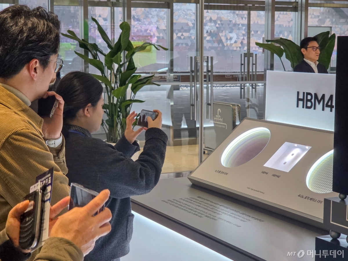 18일 오전 경기 수원시 수원컨벤션센터에서 열린 '삼성전자 제57회 정기주주총회'에 참석한 한 주주가 전시된 HBM4·HBM4E 칩의 실물 사진을 찍고 있다./사진=최지은 기자