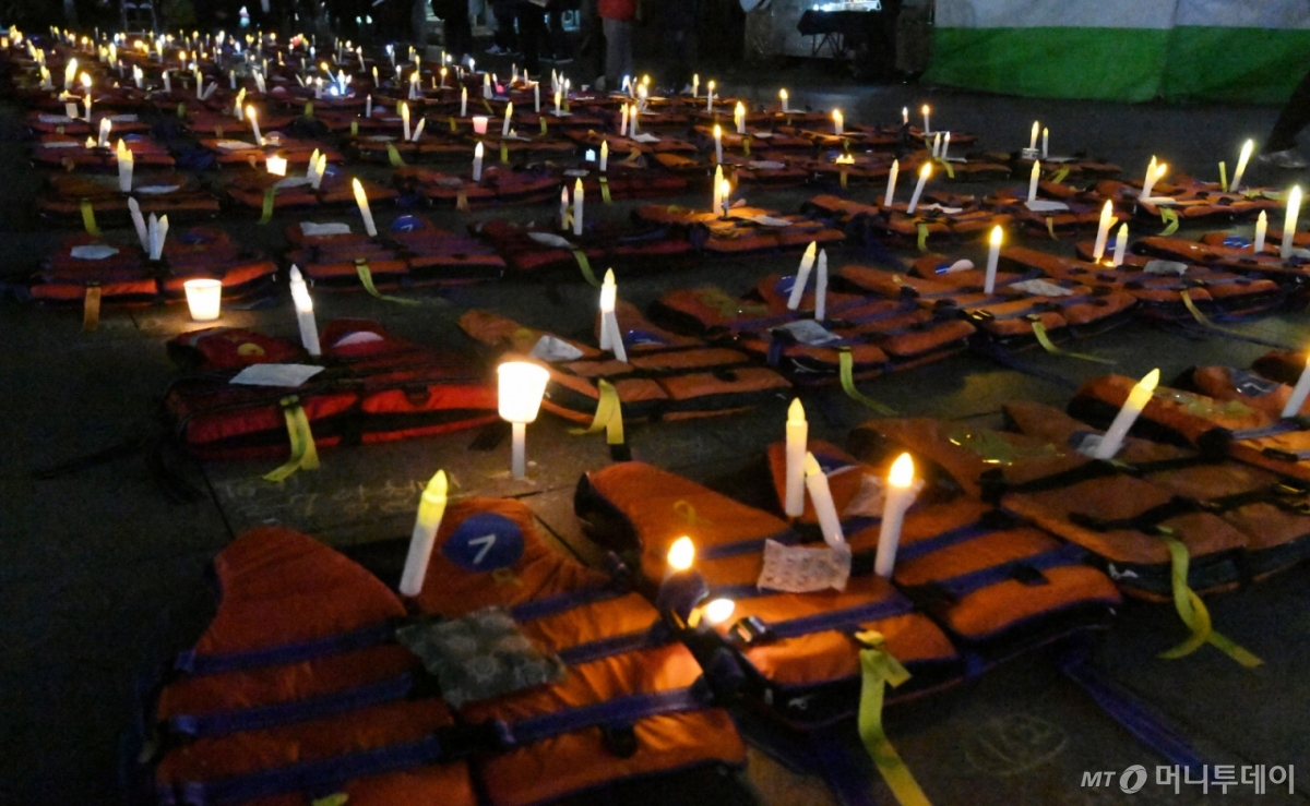 $ 박근혜 대통령 탄핵 소추안이 가결된 이튿날인 10일 오후 서울 광화문 일대에서 7차 촛불집회가 진행된 가운데 세월호 희생자를 기리는 의미로 304벌의 구명조끼에 촛불이 놓여져 있다. /사진=김창현 기자 chmt@