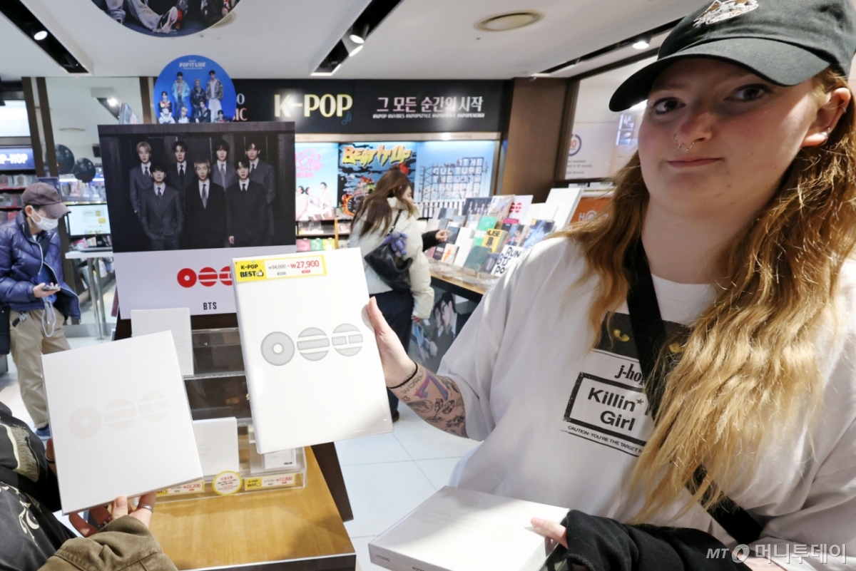 [서울=뉴시스] 조성우 기자 = 20일 오후 서울 종로구 교보문고 광화문점에서 해외 팬이 방탄소년단(BTS) 5집 앨범 '아리랑'을 들어 보이고 있다. 2026.03.20./사진=조성우