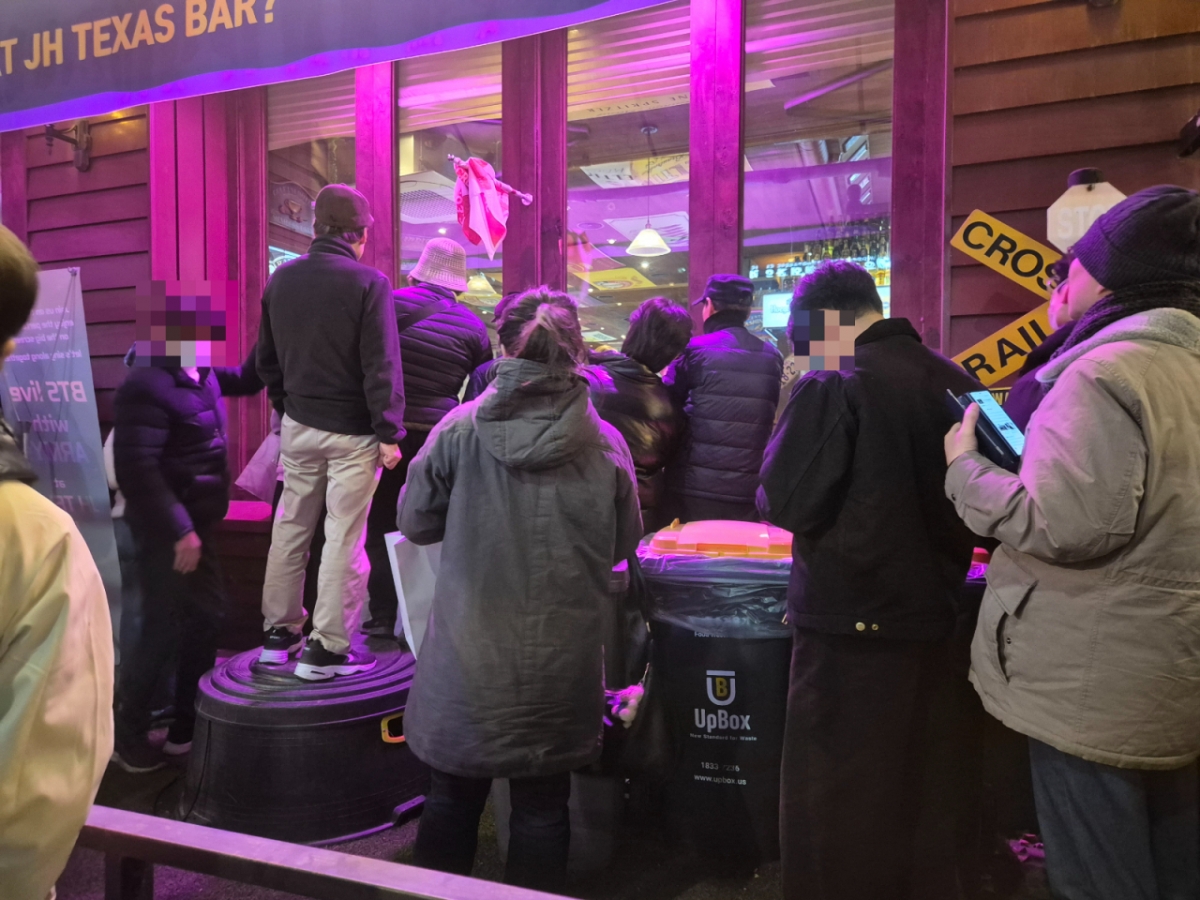 21일 오후 BTS 컴백 공연이 시작되자 일부 시민들은 청계 광장 식당 바깥에서 내부 스크린에 나오는 공연 영상을 보는 모습./사진=박진호 기자.