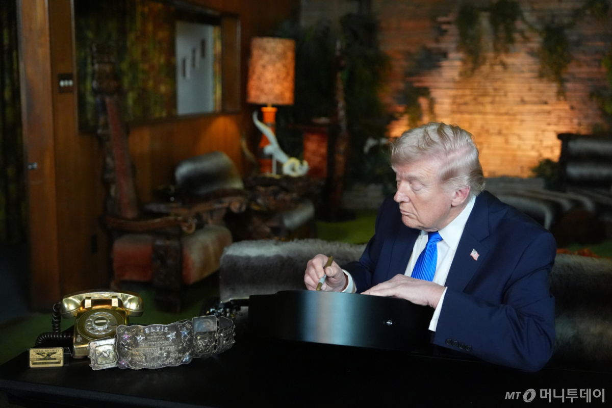 [멤피스=AP/뉴시스] 도널드 트럼프 미국 대통령이 23일(현지 시간) 테네시주 멤피스에 있는 '로큰롤의 황제' 고(故) 엘비스 프레슬리의 저택 '그레이스랜드'를 방문해 프레슬리 기타 복제품에 서명하고 있다. 트럼프 대통령은 본인의 집권 2기 출범 이후 멤피스 범죄율이 낮아졌다며 "그 점은 엘비스도 기뻐할 것"이라고 말했다. 2026.03.24. /사진=민경찬