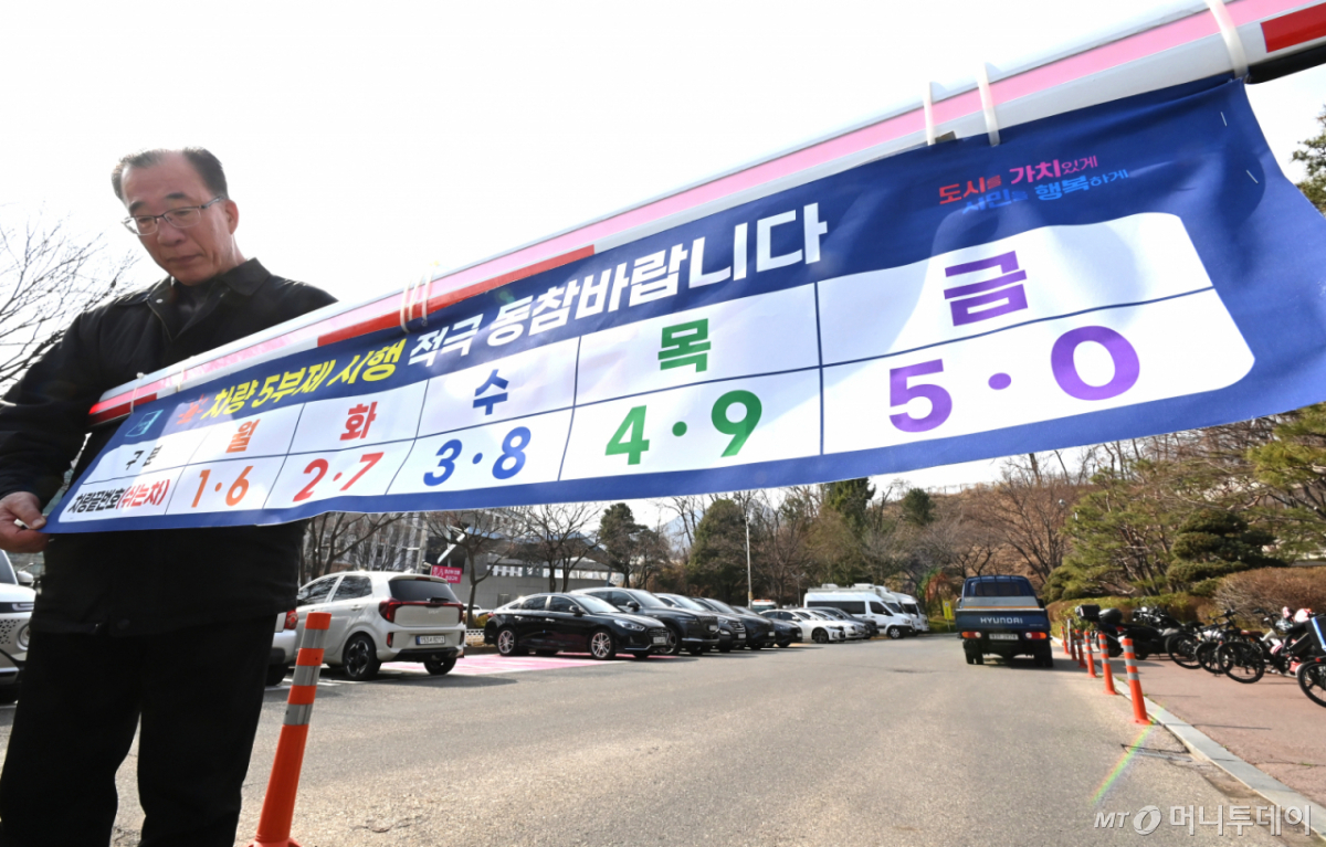 [군포=뉴시스] 김종택 기자 = 24일 경기 군포시청 주차장 입구에서 직원들이 내일부터 시행하는 차량 5부제를 앞두고 안내문을 설치하고 있다.   정부는 중동 사태로 원유 수급 위기가 확산되자 내일부터 공공부문에 대한 승용차 5부제를 시행한다. 2026.03.24. jtk@newsis.com /사진=김종택