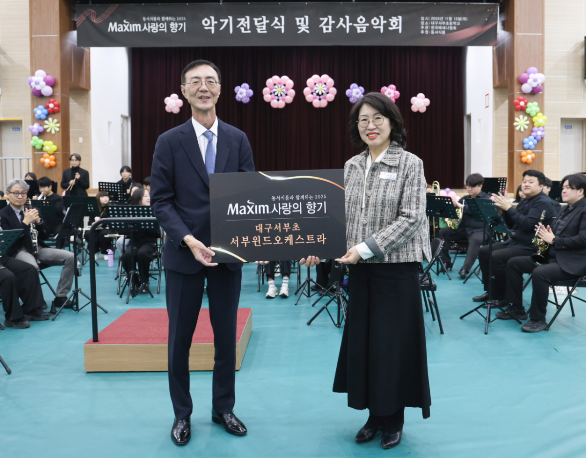 지난해 11월 13일 대구서부초등학교에서 열린 ‘제18회 맥심 사랑의 향기’ 행사에서 동서식품 최상인 홍보상무(왼쪽)와 대구서부초등학교 이보경 교장(오른쪽)이 기념촬영을 하고 있다./사진=동서식품