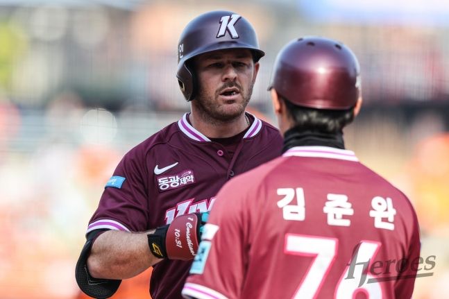 브룩스(왼쪽)가 안타를 날리고 김준완 코치에게 장비를 건네주고 있다. /사진=키움 히어로즈 제공