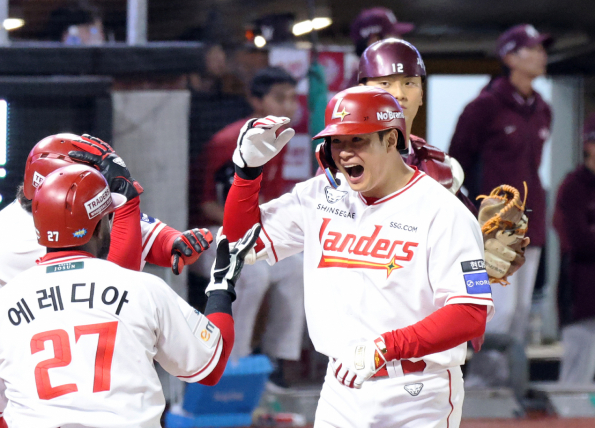 홈런을 때려낸 뒤 홈을 밟은 김재환(오른쪽)이 환한 미소로 에레디아와 함께 세리머니를 하고 있다. /사진=강영조 선임기자