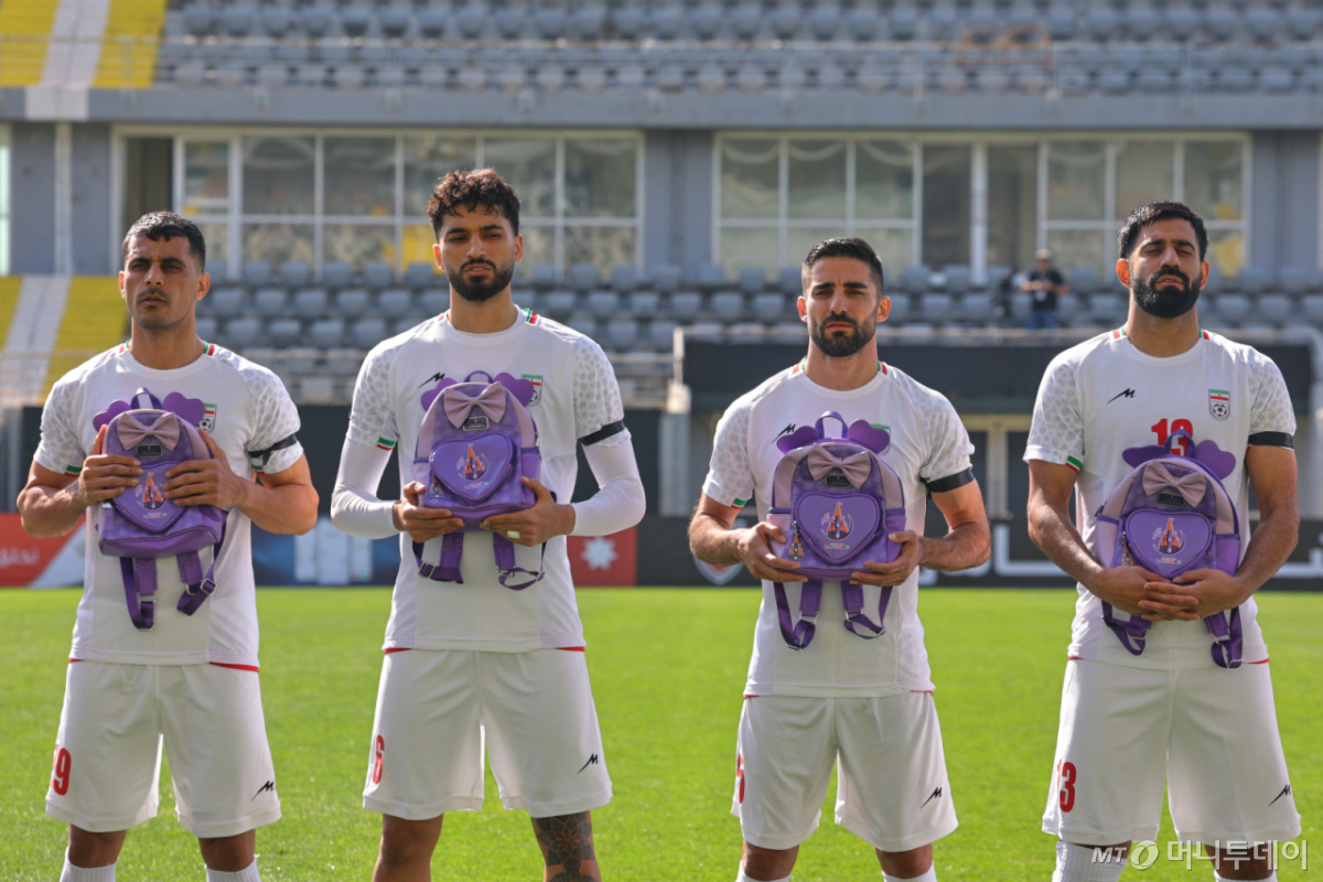 이란 축구대표팀 선수들이 지난 3월 27일(현지 시간) 튀르키예 안탈리아에서 열리는 나이지리아와 평가전을 앞두고 미군의 공습으로 숨진 어린이들을 상징하는 가방을 들고 국가를 제창하고 있다. /사진=뉴시스