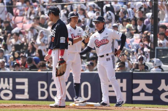 정수빈(가운데)이 안타를 날리고 임재현 코치(오른쪽)의 독려를 받고 있다. /사진=두산 베어스 제공