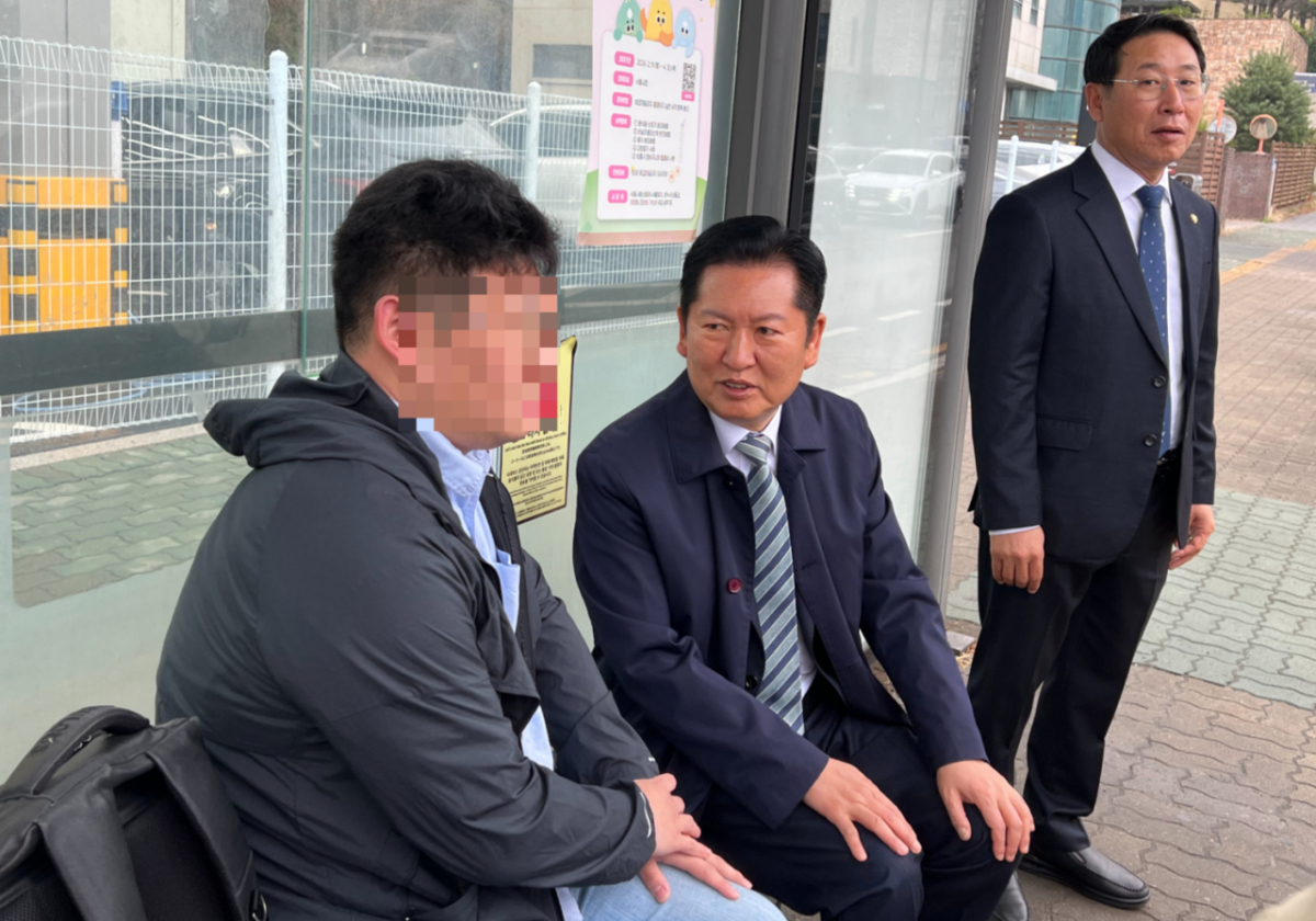 정청래 더불어민주당 대표와 김영환 대표 정무실장이 6일 오전 서울 마포구 버스정류장에서 시민과 대화를 나누고 있다./사진=이승주 기자.