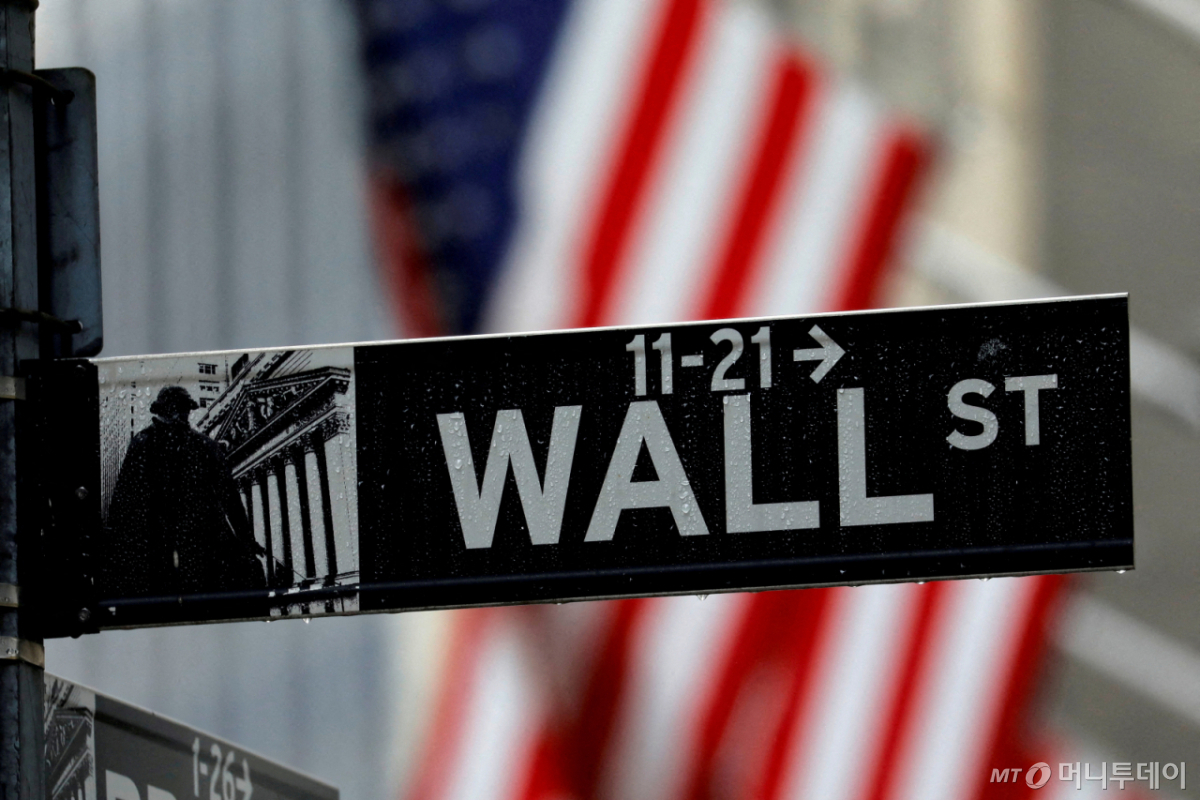 Raindrops hang on a sign for Wall Street outside the New York Stock Exchange in Manhattan in New York City, New York, U.S., October 26, 2020. REUTERS/Mike Segar/File Photo