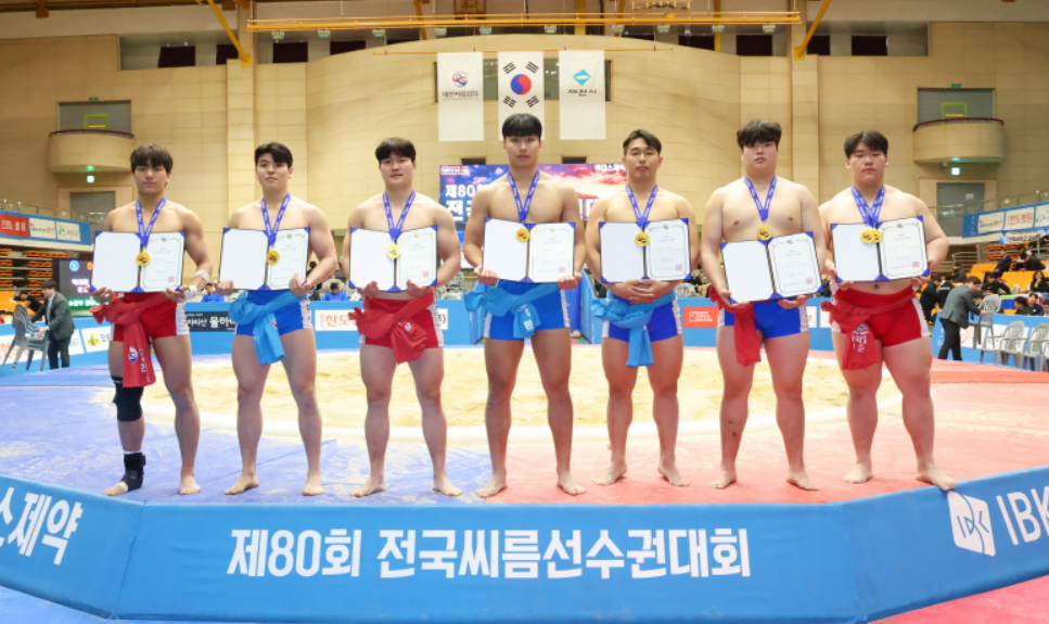 '제80회 전국씨름선수권대회' 대학교부 개인전에서 1위를 차지한 김현우(한림대학교), 이용수(울산대학교), 강준수(경기대학교), 박주환(울산대학교), 김민규(동아대학교), 전민규(영남대학교), 이혁준(인하대학교)가 메달을 메고 상장을 들고 기념사진을 찍고 있다(왼쪽부터). /사진=대한씨름협회 제공