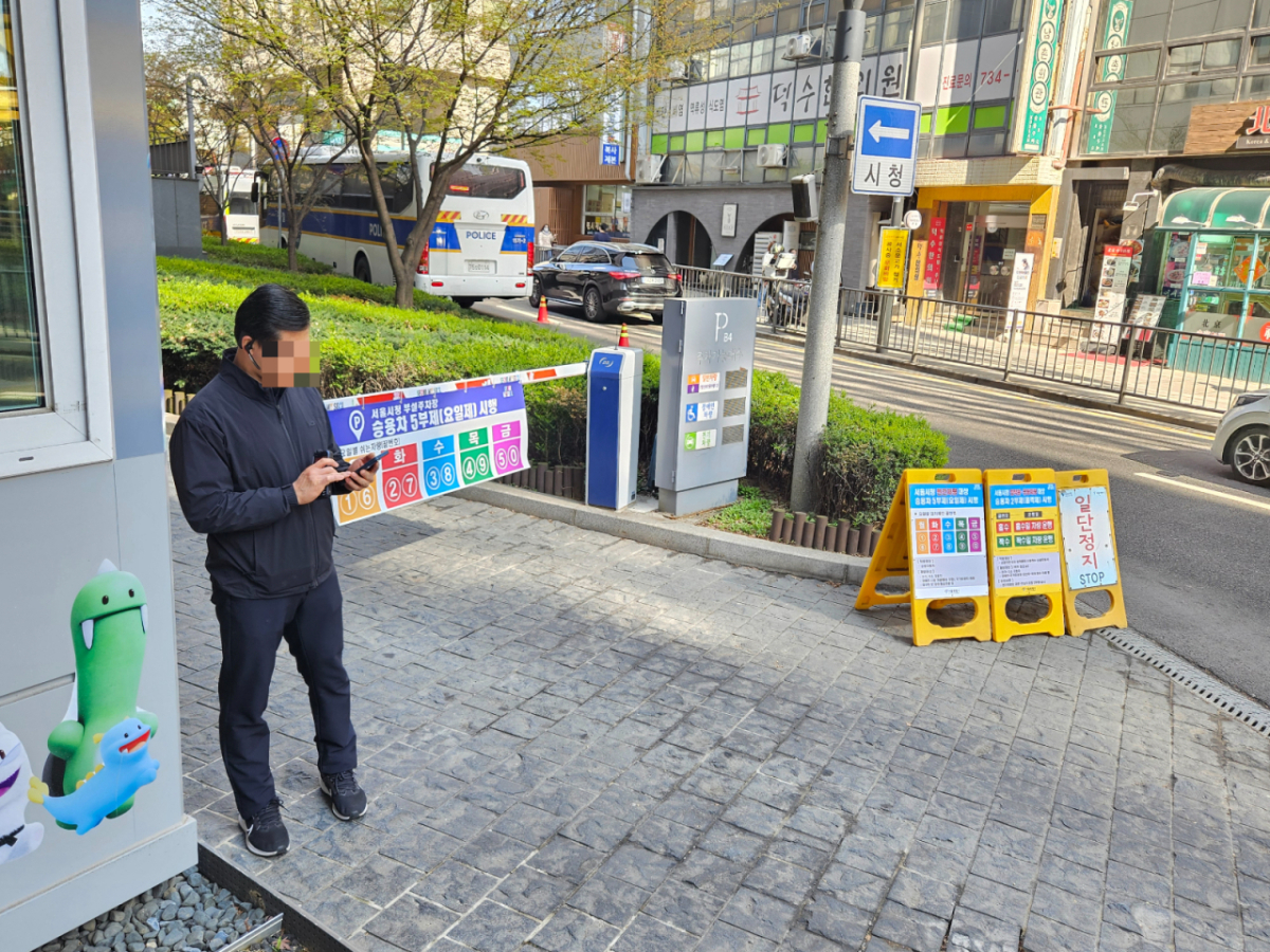 8일 오전 서울시청 주차장 앞 모습. 한 직원이 주차장 차단기 앞에서 출입차량을 안내하고 있다./사진=박상혁 기자. 