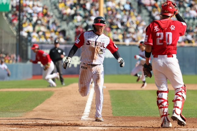 오지환(가운데)이 상대 실책을 틈타 홈을 파고들고 있다. /사진=LG 트윈스 제공
