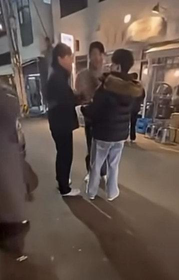 최충연(왼쪽)이 윤성빈 등과 술자리 도중 밖에서 흡연을 하며 팬서비스를 요청하는 팬을 따라하며 조롱하고 있다. /사진=온라인 커뮤니티 갈무리