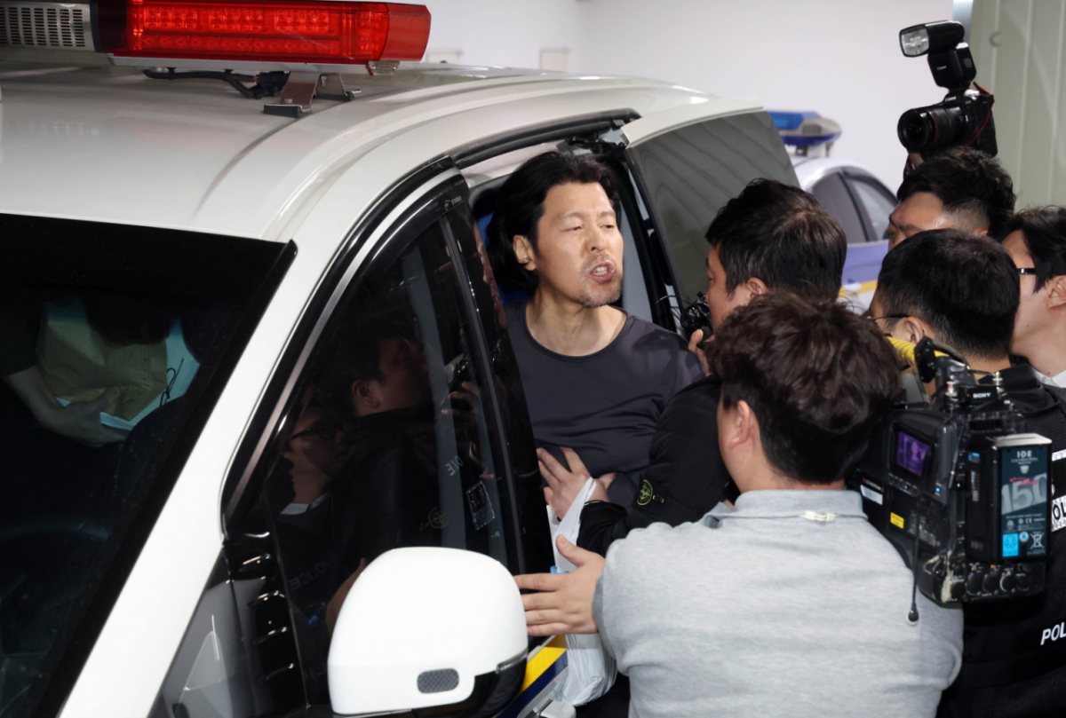 항공사 기장을 살해한 혐의로 구속된 김동환(49)이 검찰에 송치되기 위해 지난달 26일 부산진경찰서에서 호송차량에 오르며 취재진에게 자신의 입장을 밝히고 있다. /사진=뉴시스