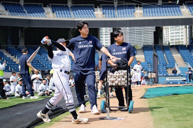 NC 김형준(왼쪽에서 2번째)이 '두드림' 야구 클리닉에서 야구 유망주의 타격을 지켜보고 있다. /사진=프로야구선수협회 제공