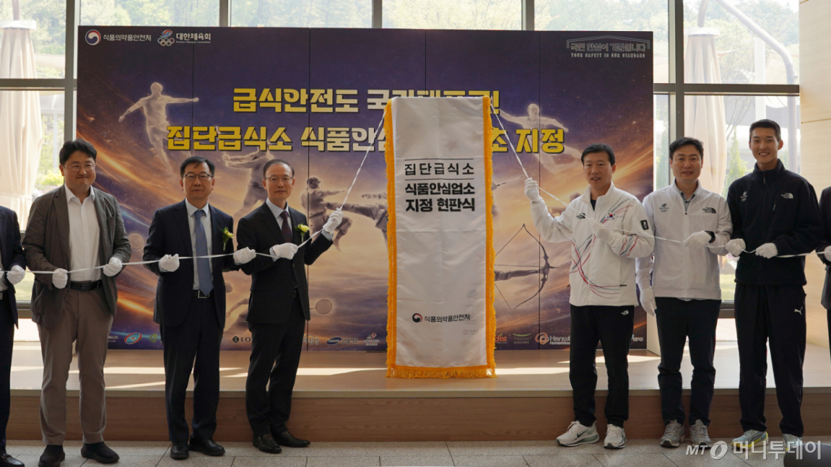 (서울=뉴스1) = 김용재 식품의약품안전처 차장이 15일 충북 진천 국가대표선수촌에서 열린 국가대표선수촌 식품안심업소 지정행사에서 김택수 국가대표선수촌장을 비롯한 참석자들과 현판식을 하고 있다. (식품의약품안전처 제공. 재판매 및 DB 금지) 2026.4.15/뉴스1 Copyright © 뉴스1. All rights reserved. 무단 전재 및 재배포, AI학습 이용 금지. /사진=(서울=뉴스1)
