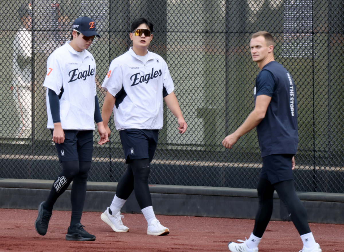 한화 김서현(가운데)이 15일 대전 한화생명볼파크에서 열린 2026 신한 SOL KBO리그 삼성 라이온즈전을 앞두고 새로 마루미를 맡게 된 잭 쿠싱(오른쪽)과 스쳐지나고 있다. /사진=강영조 선임기자