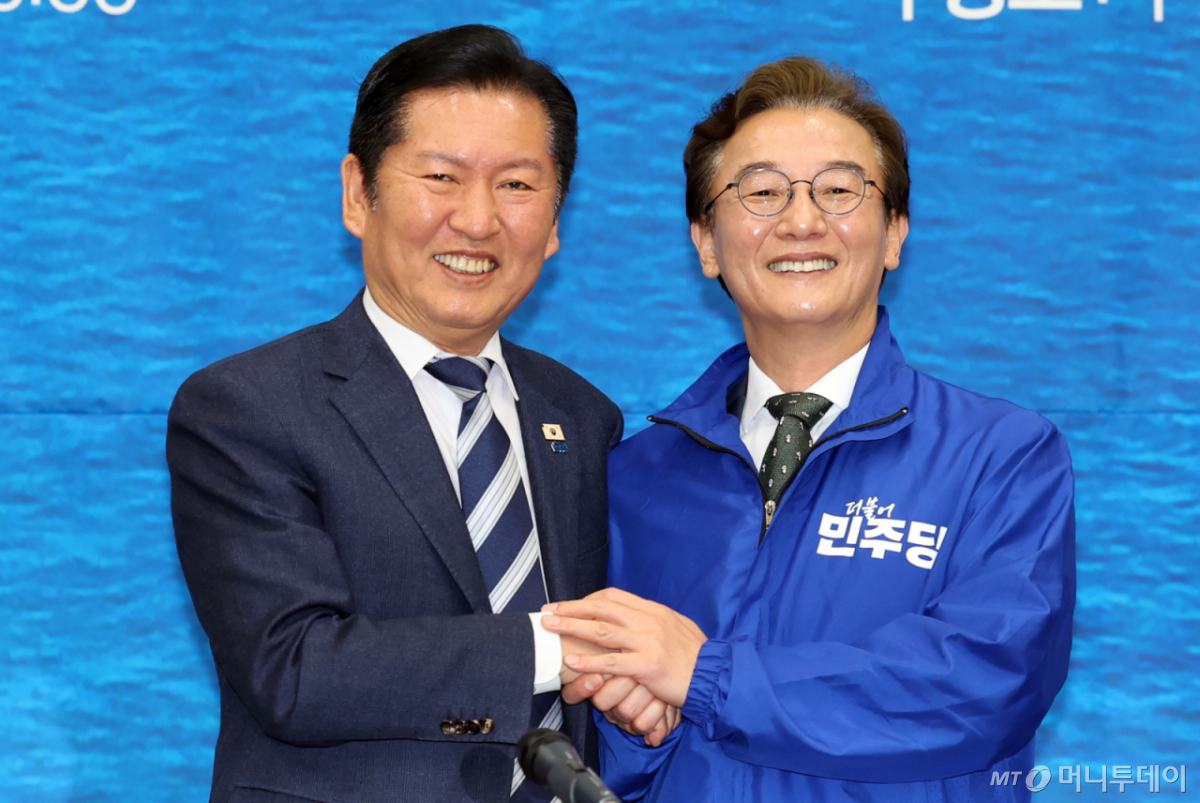 [부산=뉴시스] 하경민 기자 = 정청래 더불어민주당 대표가 15일 부산 동구 부산항 국제전시컨벤션센터에서 열린 부산 현장 최고위원회 회의에 참석, 전재수 부산시장 후보에게 파란 점퍼를 입혀주고 있다. 2026.04.15. yulnetphoto@newsis.com /사진=하경민