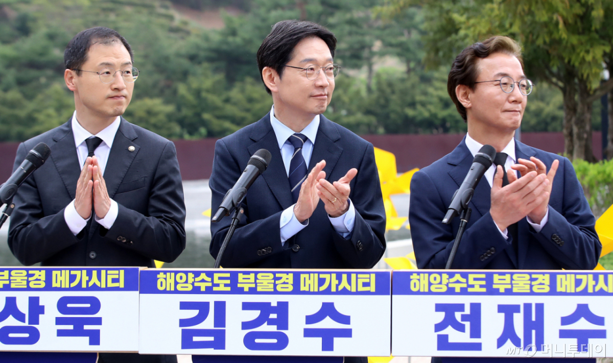 (김해=뉴스1) 윤일지 기자 = 더불어민주당 김경수 경남도지사 후보, 전재수 부산시장 후보, 김상욱 울산시장 후보가 14일 오전 경남 김해 진영읍 봉하마을에서 해양수도 부울경 메가시티 공동 기자회견 중 손뼉을 치고 있다. 2026.4.14/뉴스1  Copyright © 뉴스1. All rights reserved. 무단 전재 및 재배포,  AI학습 이용 금지. /사진=(김해=뉴스1) 윤일지 기자