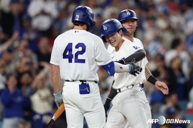 LA 다저스 김혜성이 16일(한국시간) 미국 캘리포니아주 로스앤젤레스 유니클로 필드 앳 다저스타디움에서 열린 뉴욕 메츠와 2026 메이저리그(MLB) 홈경기에서 2회 투런 홈런을 터트리고 홈을 밟은 뒤 동료들의 환영을 받고 있다. /AFPBBNews=뉴스1