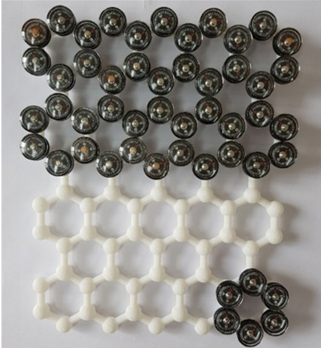 2차원 자성 반데르발스 연구 분야의 정체성과 학문적 도약을 한눈에 보여주는 개념도. 전체적인 이미지는 3D 프린팅으로 정교하게 제작된 구조물 형상을 띠고 있으며, 대표적인 2차원 물질인 '그래핀(Graphene)'과 유사한 벌집 모양(Honeycomb)의 2차원 골격(framework)을 바탕으로 하고 있다. 가장 눈에 띄는 시각적 특징은 탄소 원자가 있어야 할 격자의 뼈대 자리에 '작은 나침반'들이 배치되어 있다는 점이다. 이는 비자성 2차원 물질인 그래핀의 탄소 원자가 자성을 띤 전이금속 원자로 치환해, 원자 한 층 두께의 2차원 평면 자체에서 내재적 자성을 구현해 냈다는 연구 분야의 패러다임 전환을 직관적으로 보여준다./그림설명 및 그림제공 : 서울대학교 물리천문학부 박제근 교수