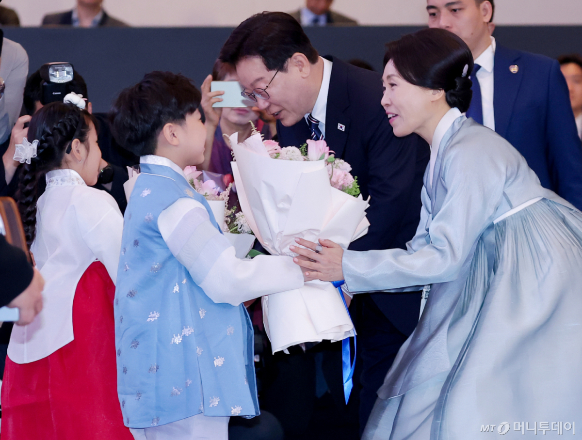 (하노이(베트남)=뉴스1) 이재명 기자 = 베트남을 국빈 방문 중인 이재명 대통령과 김혜경 여사가 22일(현지시간) 하노이의 한 호텔에서 열린 동포 오찬 간담회에서 화동에게 꽃다발을 받고 있다. 2026.4.22/뉴스1  Copyright © 뉴스1. All rights reserved. 무단 전재 및 재배포,  AI학습 이용 금지. /사진=(하노이(베트남)=뉴스1) 이재명 기자
