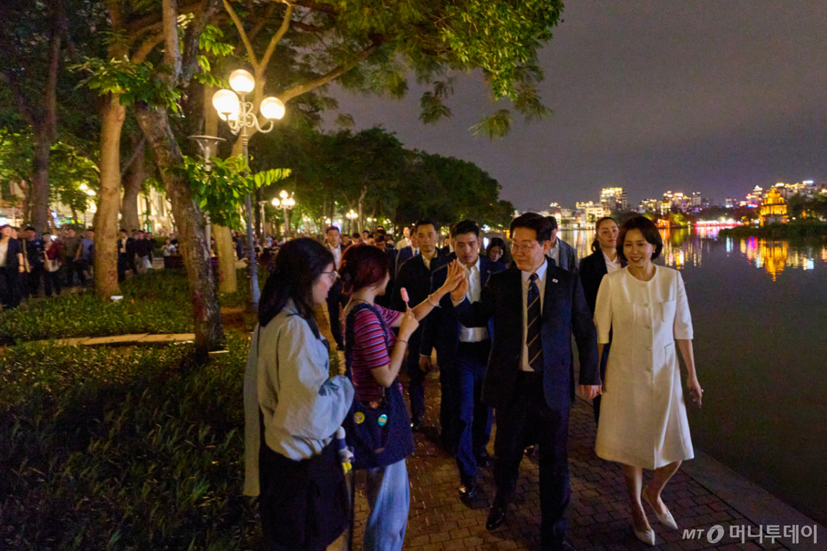 [서울=뉴시스] 고범준 기자 = 이재명 대통령과 김혜경 여사가 23일(현지 시간) 베트남 하노이 시내를 산책하고 있다. (사진=이재명 대통령 SNS) 2026.04.24. photo@newsis.com *재판매 및 DB 금지 /사진=