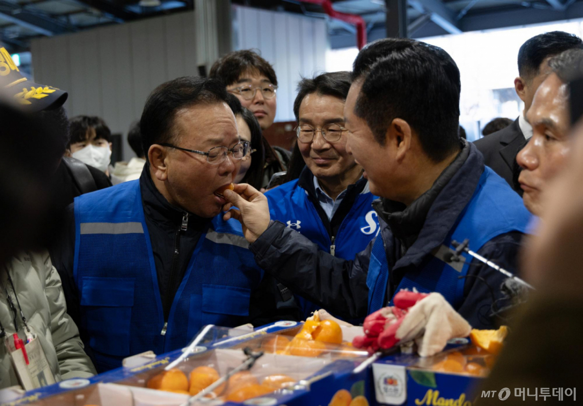 [서울=뉴시스] 정청래 더불어민주당 대표가 8일 오전 대구 북구 매천동 농수산물도매시장에서 민생현장 체험을 하던 중 김부겸 민주당 대구시장 후보에게 귤을 먹여주고 있다.(사진=더불어민주당 제공) 2025.04.08. *재판매 및 DB 금지 /사진=