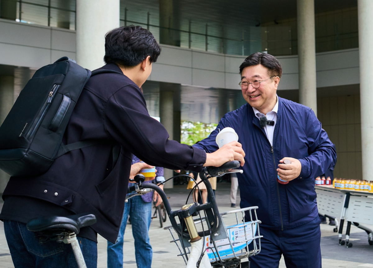 윤호중 행정안전부 장관(오른쪽)이 지난 22일 '자전거의 날'을 맞아 세종시 공영 자전거를 타고 정부세종청사를 출근한 후 출근한 직원들을 직접 맞이하며 음료를 건네고 있다. /사진제공=행정안전부