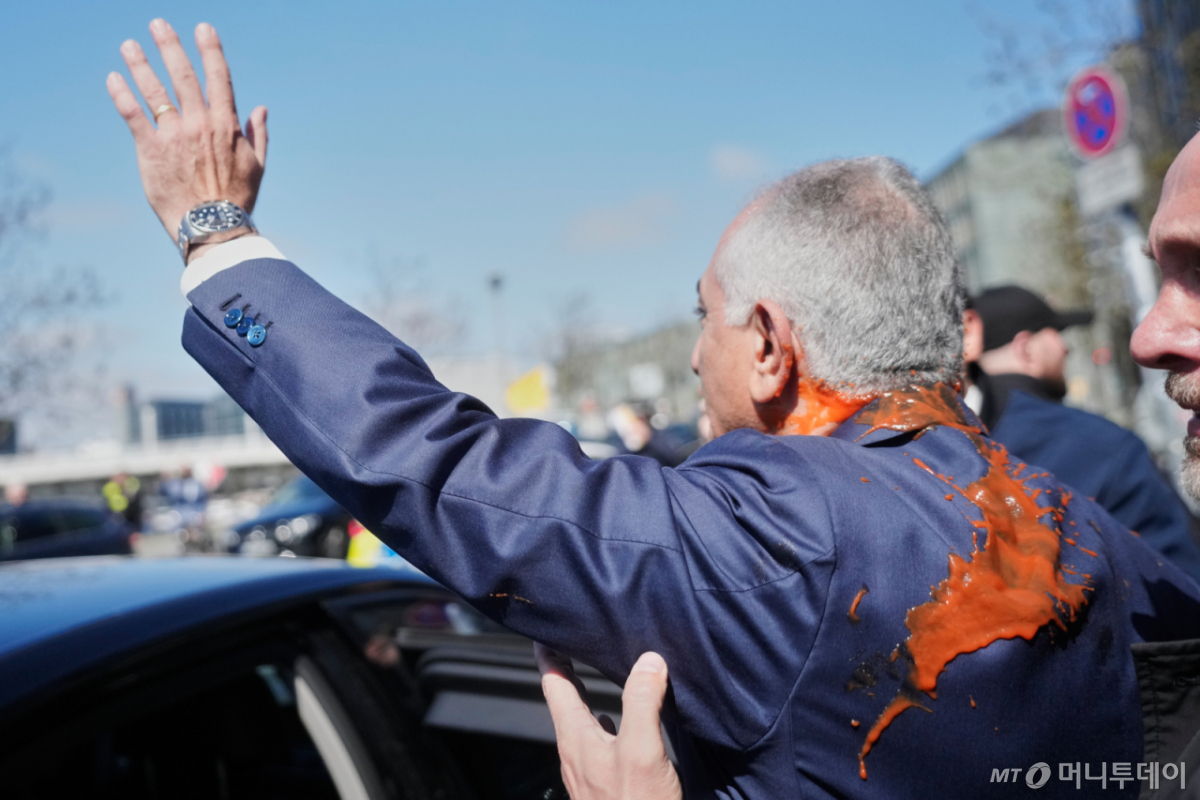 미국에 망명 중인 레자 팔레비 전 이란 왕세자가 23일(현지 시간) 독일 베를린에서 미국과 이란의 휴전을 비난하는 기자회견을 마친 후 붉은 액체 테러를 당한 채 차량에 탑승하며 지지자들에게 손을 흔들고 있다. /사진=뉴시스