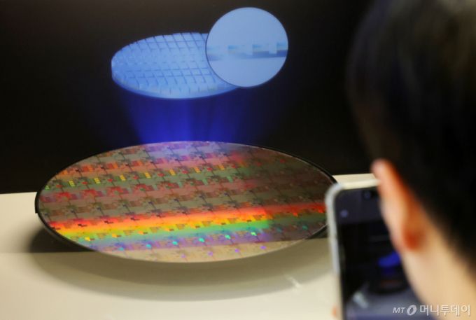 11일 오후 서울 강남구 코엑스에서 열린 세미콘 코리아 2026를 찾은 한 관람객이 반도체 웨이퍼 사진을 찍고 있다. 2026.02.11. /사진=뉴시스
