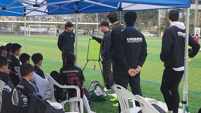 송현식(가운데) 감독이 경기 중 유소년 선수들에게 전술을 설명하고 있다. /사진=온새미로FC 제공