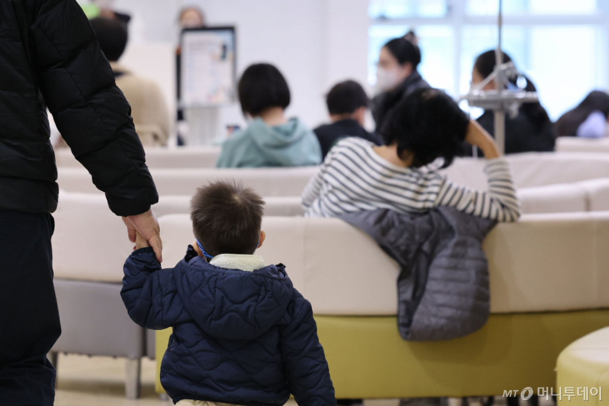 [서울=뉴시스] 권창회 기자 = 독감이 유행 중인 19일 오후 서울 성북구 우리아이들병원 진료실이 진료를 받기 위해 기다리는 어린이들로 붐비고 있다.  예년보다 한 달 이상 이른 인플루엔자 유행이 최근 10년 중 최고 수준으로 확산하며 방역당국이 경계 태세를 강화했다. 특히 초등학생 연령대에서 급증세가 두드러지면서 학령기 아동에 대한 예방접종 참여율 제고가 시급한 상황이다. 2025.11.19. kch0523@newsis.com /사진=권창회