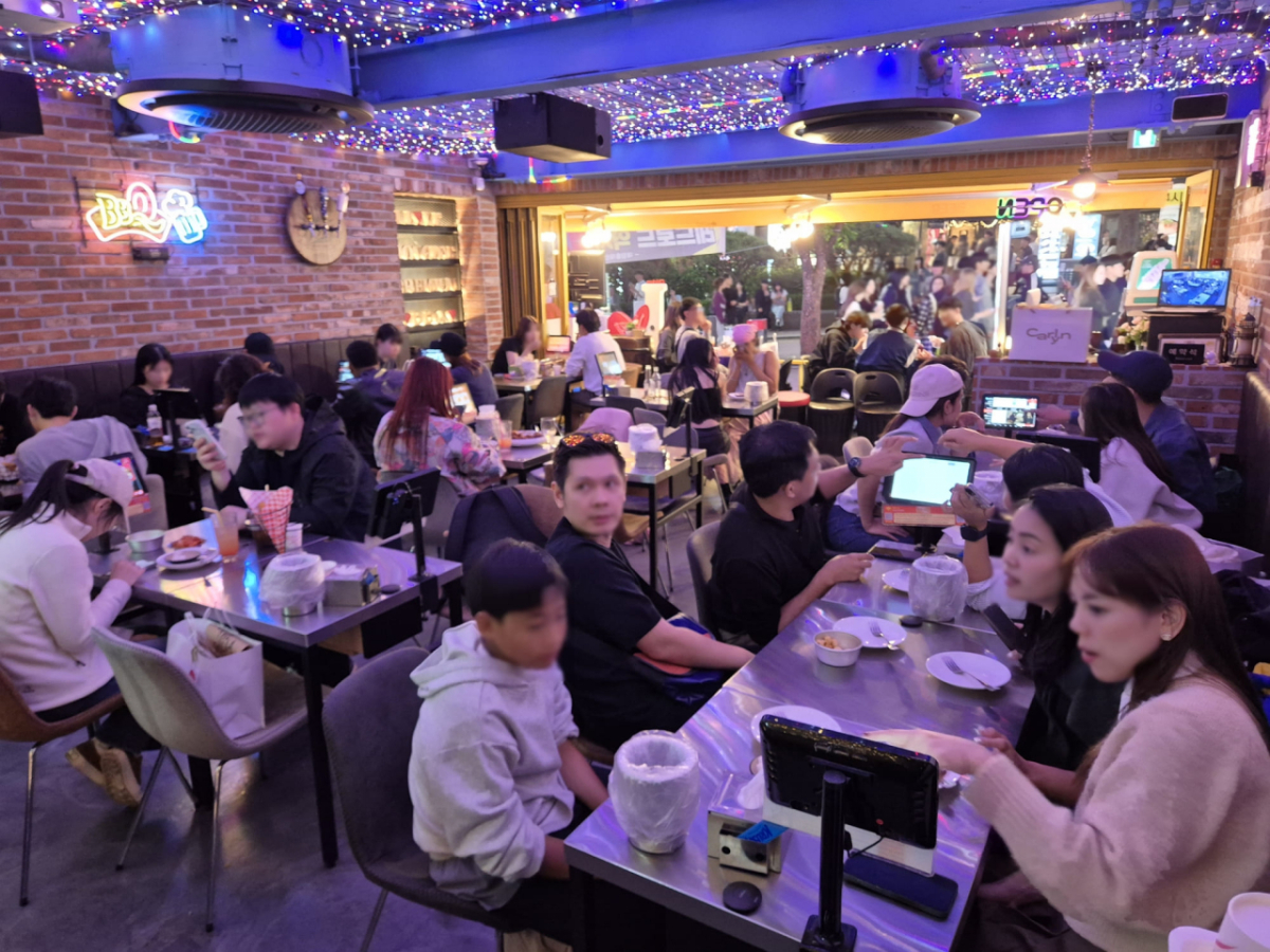 BBQ 홍대입구점을 방문한 외국인 관광객과 소비자들이 BBQ 치킨을 즐기고 있는 모습. /사진제공=제너시스BBQ