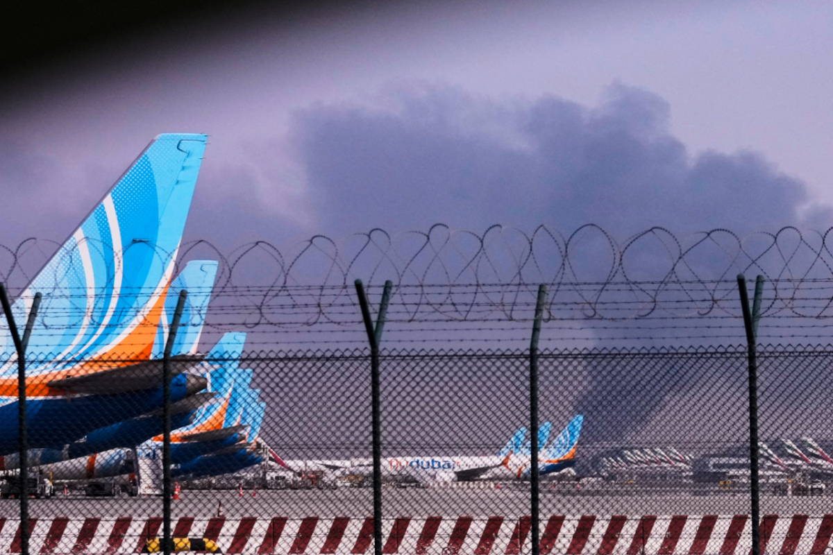 3월16일(현지 시간) 아랍에미리트(UAE) 두바이 국제공항 인근에서 드론이 연료 탱크를 타격해 연기가 치솟는 가운데 공항에 플라이 두바이 소속 항공기들이 계류하고 있다. 이 공격으로 화재가 발생하면서 항공편 운항이 일시 중단됐다. /AP=뉴시스