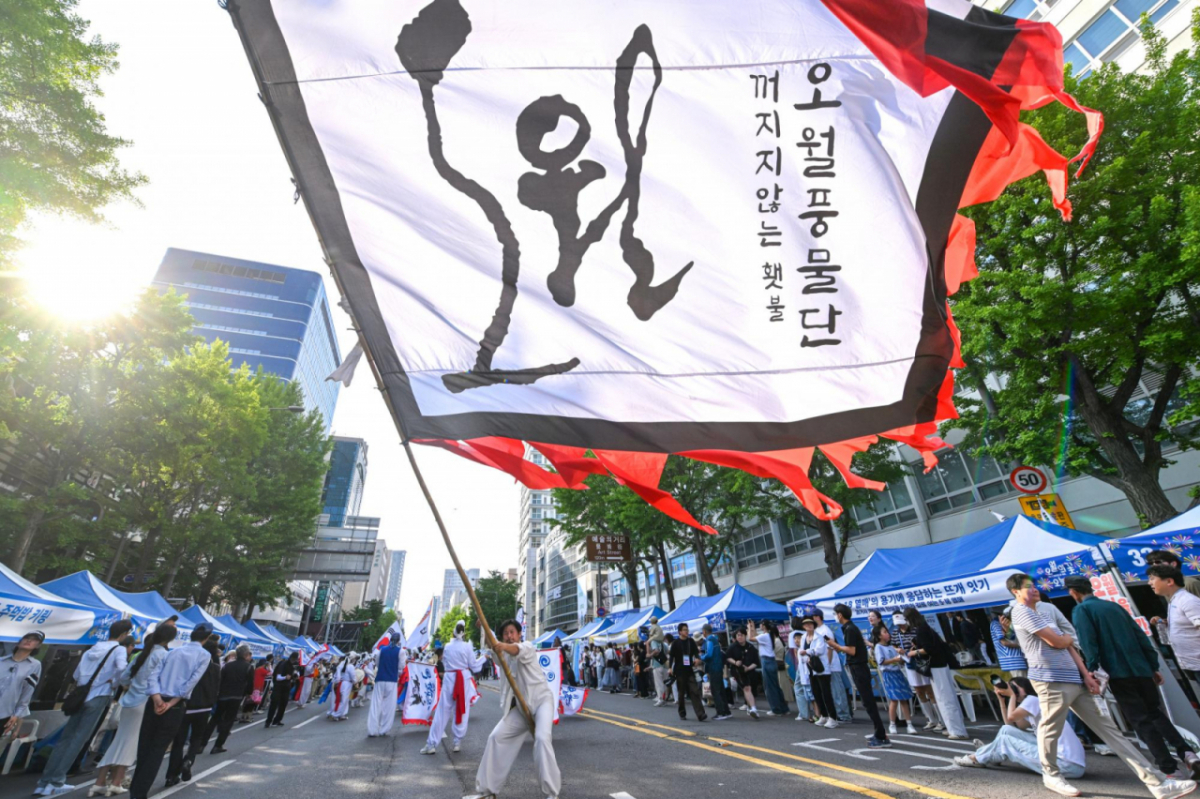 지난 16일 오후 광주 동구 금남로에서 5·18민중항쟁기념행사위원회의 민주평화대행진 행사에 참여한 오월풍물패가 대형 깃발을 흔들며 행진하고 있다. / 사진 = 뉴시스 