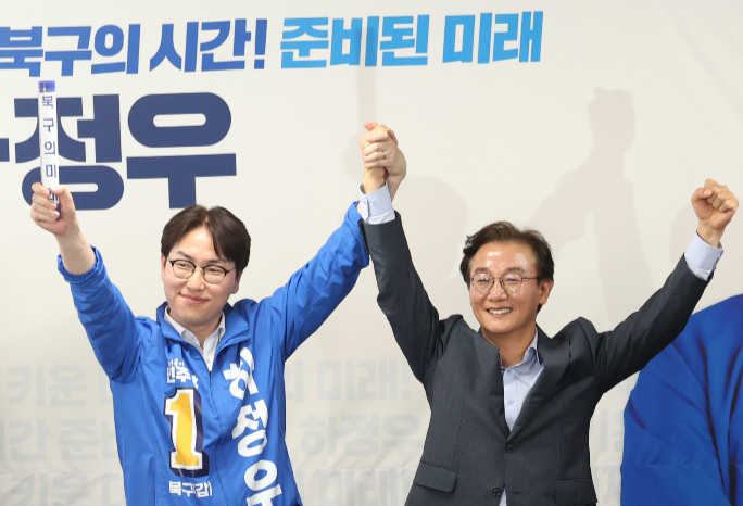하정우 더불어민주당 부산 북구갑 국회의원 보궐선거 후보가 지난 10일 부산 북구의 한 건물에서 자신의 선거사무소 개소식을 열고 전재수 부산시장 후보로부터 '북구의 미래'라고 적힌 배턴을 넘겨받은 뒤 손을 들어 인사하고 있다. /사진=뉴시스
