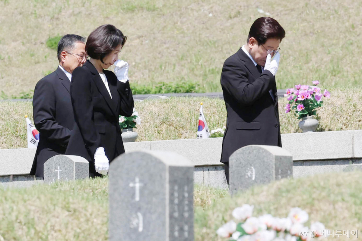 [광주=뉴시스] 고범준 기자 = 이재명 대통령과 김혜경 여사가 18일 광주 북구 국립5·18민주묘지에서 눈물을 닦으며 이동하고 있다. 2026.05.18. bjko@newsis.com /사진=