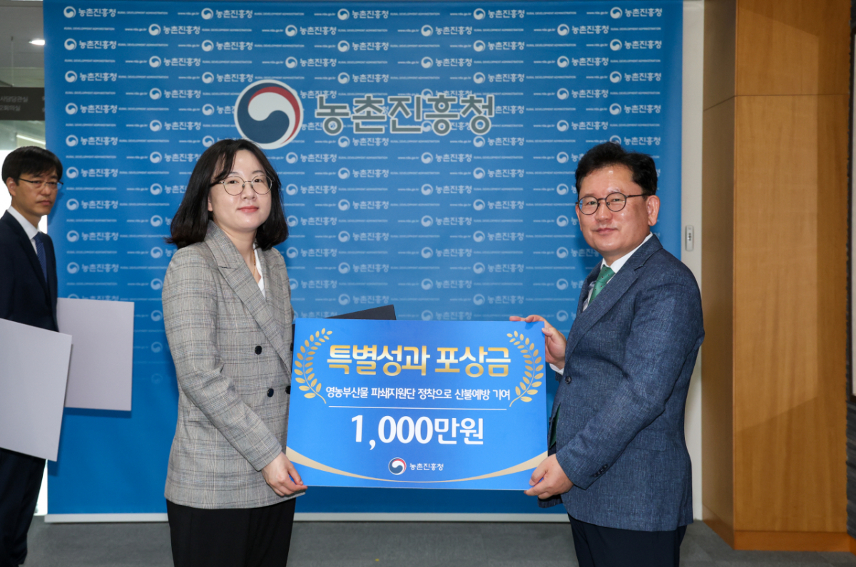 영농부산물 파쇄 지원사업 담당자인 농진청 재해대응과 정은수 농촌지도사가 이승돈 농진청장으로부터 특별성과 포상금 1000만원을 받았다./사진=농촌진흥청