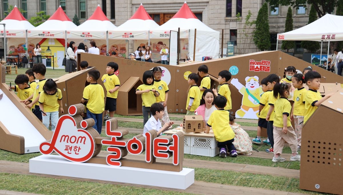 롯데는 19일부터 21일까지 서울시청 잔디광장에서 저출생 문제 해결과 돌봄 환경 개선에 대한 관심을 높이고자 '맘(mom)편한 페스티벌을 개최한다. '맘편한 페스티벌'은 등교길, 학습, 놀이, 휴식 등 4개 구역으로 나눠 시민들이 참여할 수 있는 체험형 공간으로 구성됐다. 19일 행사장을 찾은 어린이들이 맘편한 놀이터에서 체험을 하고 있다. /사진제공=롯데그룹