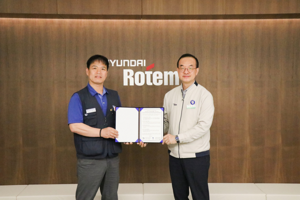 김익수 현대로템 경영지원본부장(오른쪽)과 남봉희 전국금속노동조합 현대로템 지회장이 지난 19일 현대로템 창원공장에서 열린 동반성장 노사미래전략TFT 발족식에서 기념촬영을 하고 있다./사진제공=현대로템