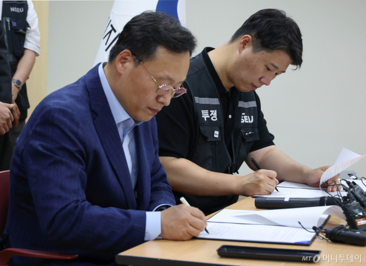 여명구 삼성전자 DS(디바이스솔루션·반도체 사업 담당) 피플팀장(왼쪽)과 최승호 삼성그룹 초기업노동조합 삼성전자지부 위원장이 20일 오후 경기 수원시 장안구 경기지방고용노동청에서 열린 삼성전자 노사교섭 결과 브리핑에서 합의안에 서명을 하고 있다. /사진=뉴시스 /사진=김종택